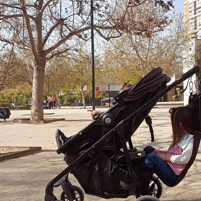 Niños jugando junto a coche con hamaca para dos peques