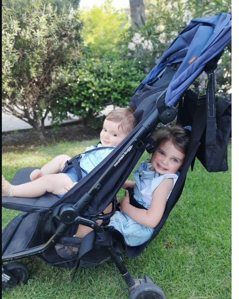 Hamaca Pepe Pillo en uso: bebé y niña paseando juntos en un coche con segundo asiento